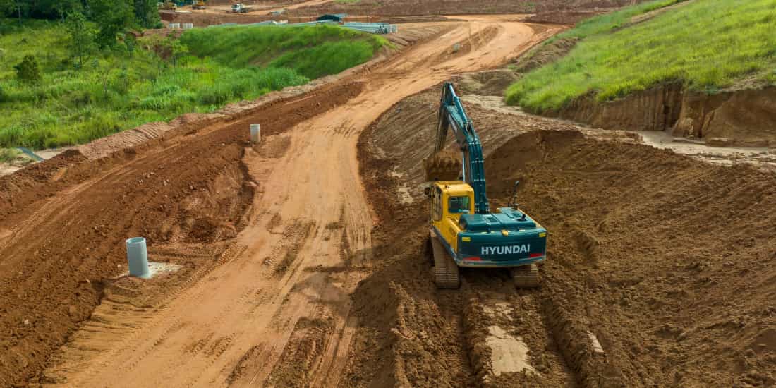 escavadeira hyundai operando em etapa de terraplanagem de estrada